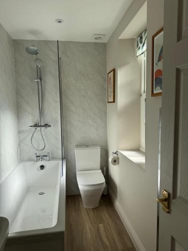 a bathroom with a shower and a toilet and a sink at Spofforth Lodge in Wetherby
