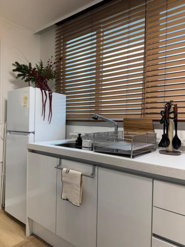 eine Küche mit weißen Schränken und einem weißen Kühlschrank in der Unterkunft NEW Stay Rombus in Seoul