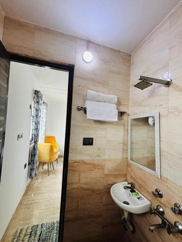 a bathroom with a sink and a mirror at Hotel Soho Corporate 62 in Ghaziabad