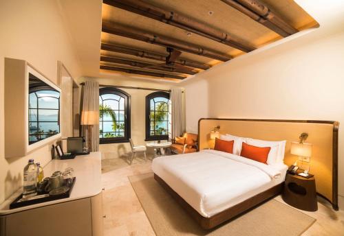 a bedroom with a large bed in a room with windows at Cunda Callisto Hotel & Spa Adult Only 12 in Ayvalık