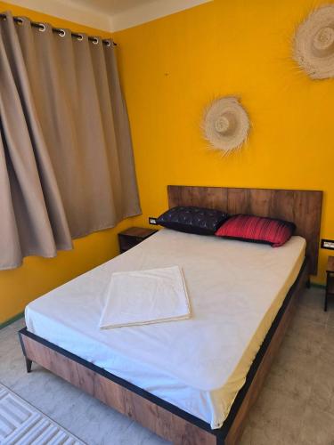 a bed in a room with a yellow wall at The Graziano 2 house in Sousse
