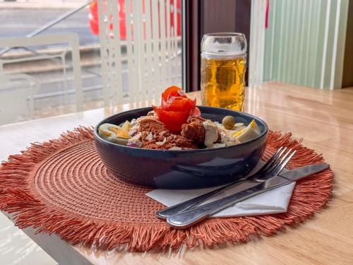 een kom eten op een tafel met een glas bier bij ibis Styles Nimes Gare Centre in Nîmes