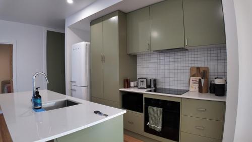 a kitchen with a sink and a refrigerator at Howick Heights Unit 3, Inner Launceston Living in Launceston