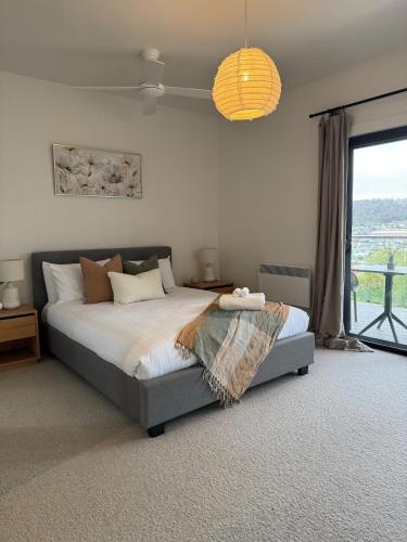 a bedroom with a bed and a large window at Howick Heights Unit 3, Inner Launceston Living in Launceston