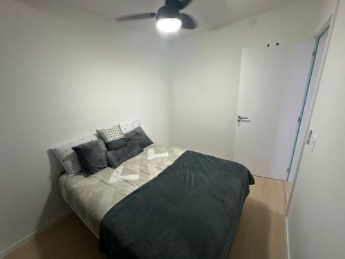 une chambre avec un lit et un ventilateur de plafond dans l'établissement Modern Apartment 500m from Beach, à Barra Velha