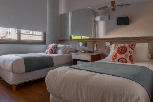 ein Hotelzimmer mit zwei Betten und einem Fenster in der Unterkunft Hotel Internacional in Mendoza
