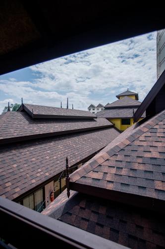 a view of roofs from a window of a building at De Thaphae Chiangmai in Chiang Mai