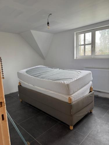 Bett in einem Zimmer neben einem Fenster in der Unterkunft Iosono by Moniek in Geel
