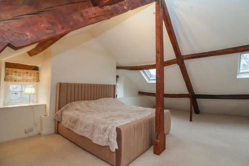 a bedroom with a large bed in a attic at Waterloo Mill Cottage in Wotton under Edge