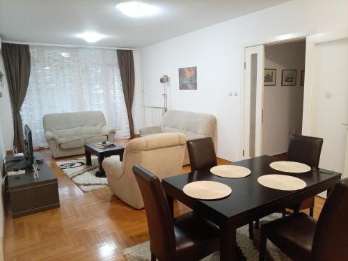 ein Wohnzimmer mit einem Tisch und einem Sofa in der Unterkunft Linda Apartments- Arena in Novi Beograd