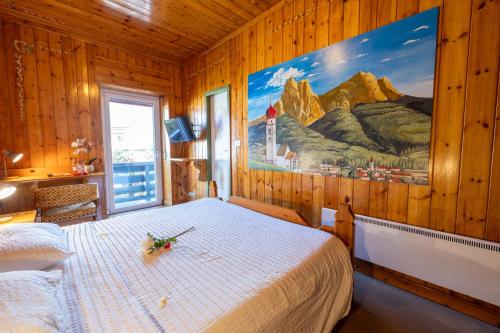 een slaapkamer met een bed en een schilderij aan de muur bij Villaggio Hotel Aquila in Calliano