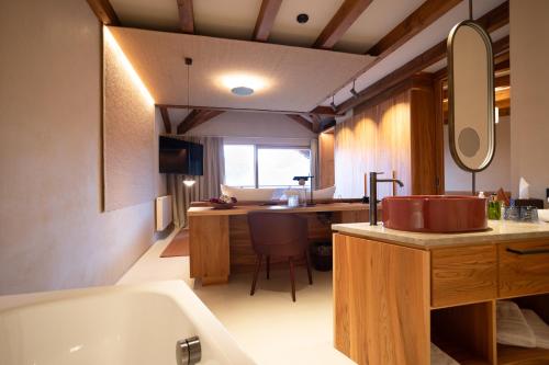 a bathroom with a tub and a sink and a desk at Hotel Schönblick in Rodengo