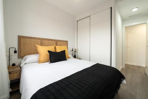 ein Schlafzimmer mit einem großen Bett mit gelben Kissen in der Unterkunft Getafe Suites in Getafe