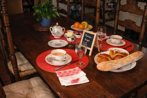 un tavolo di legno con pane, tazze e bicchieri di vino di Au fil du temps 54 a Lironville