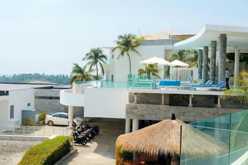 een villa met een zwembad en een huis bij The Seaview Kata in Kata Beach