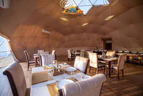 un restaurant avec des tables et des chaises et un plafond dans l'établissement Crystal Resort, à Sām