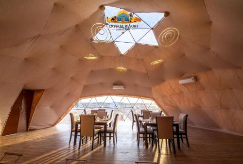 un restaurant avec un plafond en bois, des tables et des chaises dans l'établissement Crystal Resort, à Sām