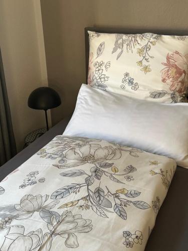 een bed met een wit dekbed met bloemen erop bij Helpens Hof in Salzhausen