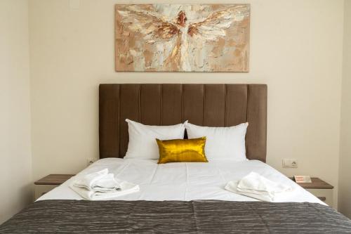 a bed with white sheets and a yellow pillow at Апартамент 8 in Lovech