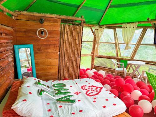 una camera con letto con palloncini rossi e bianchi di Hotel Glamping Horse a Dosquebradas