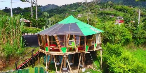 una casa sull'albero con un tetto verde su una collina di Hotel Glamping Horse a Dosquebradas
