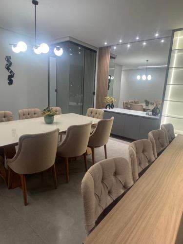 una sala da pranzo con tavolo e sedie bianchi di Casa espaçosa e acolhedora a Ponta Porã