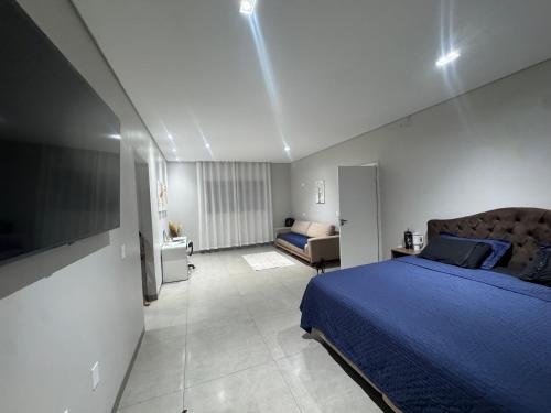 a bedroom with a blue bed and a television at Casa completa acomoda até 10 hóspedes, 5 quartos, 4 camas casal e 2 solteiro in Ponta Porã