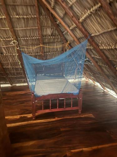 a bed in a tent with a blue net at Finca Buena Vida Hostel in Popoyo