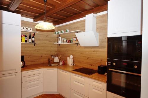 una cucina con mobili bianchi e un microonde nero di Landhaus in den Weinbergen 