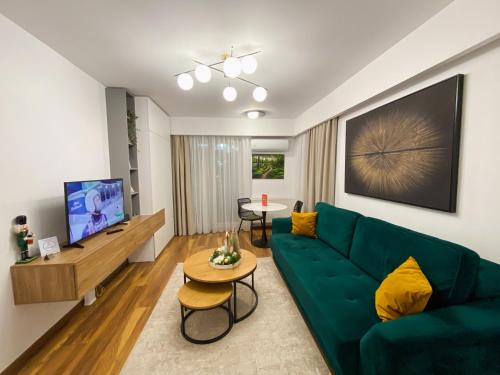 a living room with a green couch and a table at Alegria Avantgarden Brasov in Braşov