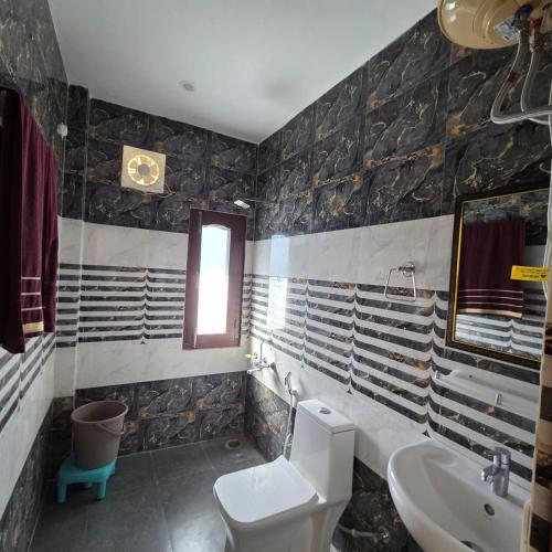 a bathroom with a toilet and a sink at The Sunrise Retreat in Solan