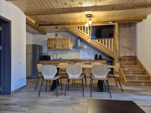 a kitchen and dining room with a table and chairs at Gray River Resort in Obarsia-Lotrului