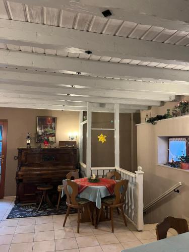 une salle à manger avec une table et un piano dans l'établissement Weingut Günther und Gästezimmer, 