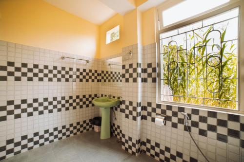 甘托克Bambi Farmstay的浴室铺有黑白瓷砖,设有窗户。
