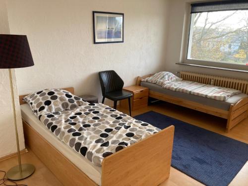 a bedroom with a bed and a chair and a window at Daios in Wathlingen