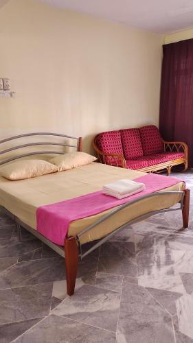 a bedroom with two beds and a couch at Rose Condo@ Cocobay Beach Resort in Port Dickson