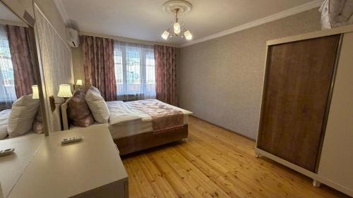 ein Schlafzimmer mit einem Bett und einem großen Fenster in der Unterkunft Sheki Central Apartment Deluxe in Şəki