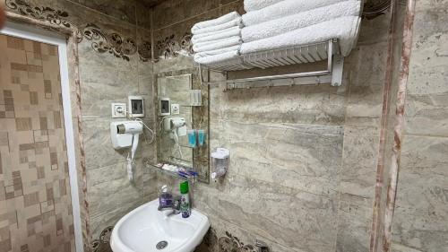 ein Badezimmer mit Waschbecken und Spiegel in der Unterkunft Sheki Central Apartment Deluxe in Şəki