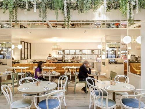 due persone sedute ai tavoli di un ristorante di Pullman Brisbane King George Square a Brisbane