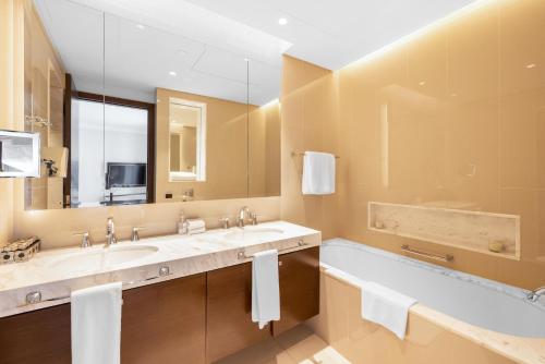 a bathroom with two sinks and a large mirror at The Address Fountain Views - Residence 2 Bedroom with Burj Khalifa view and access to Dubai mall in Dubai