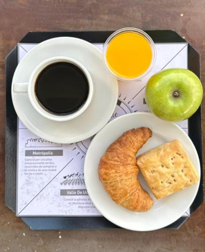 ein Teller Essen mit einer Tasse Kaffee und einem Apfel in der Unterkunft Hotel Internacional in Mendoza