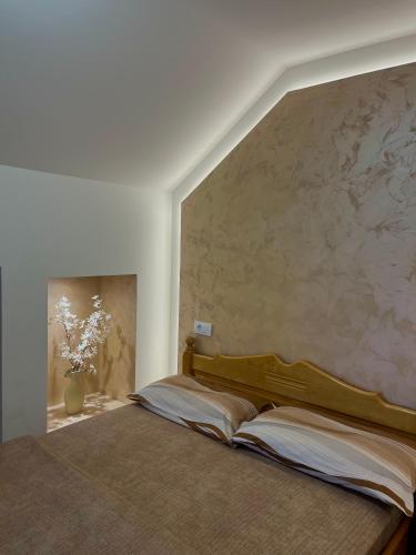 a bed in a bedroom with a large wall at Apartmani Ristanović in Zlatibor