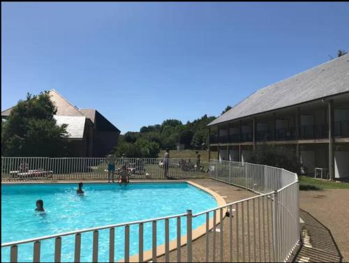ein Schwimmbad vor einem Gebäude in der Unterkunft Studio moderne avec Balcon à 5 min de Honfleur parking et piscine in Équemauville