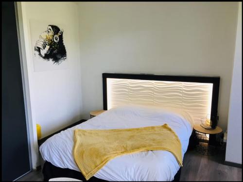 ein Schlafzimmer mit einem Bett mit einer Decke darauf in der Unterkunft Studio moderne avec Balcon à 5 min de Honfleur parking et piscine in Équemauville