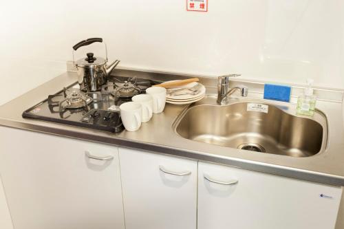 
a kitchen sink with a stainless steel dishwasher at Kyostay Iroha Toji Annex in Kyoto
