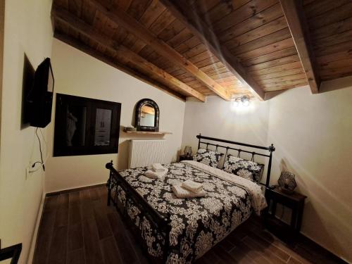 una camera da letto con un letto in una stanza con soffitti in legno di Αυγήλιον - Private Mountain House a Synikia Mesi Trikalon