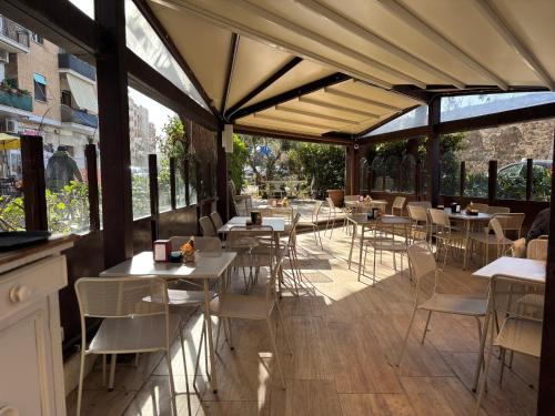 un ristorante con tavoli, sedie e finestre di Be Your Home - Guest House Colors a Civitavecchia