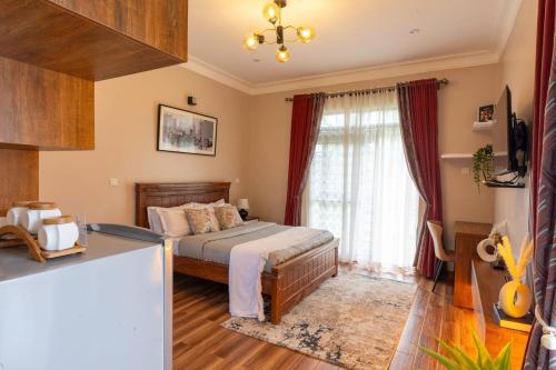 a bedroom with a bed and a large window at Mivida Residences in Bulindo