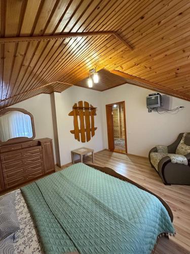 a bedroom with a large bed and a couch at Karpatskyi Maetok in Slavske