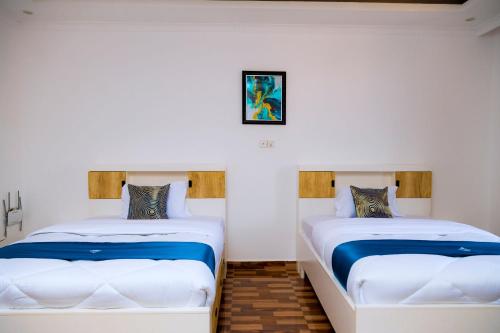 twee bedden naast elkaar in een kamer bij Million Views Kigali in Kigali